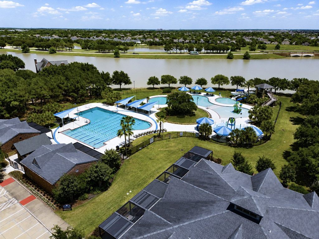 Aerial drone view of a community resort pool and lake